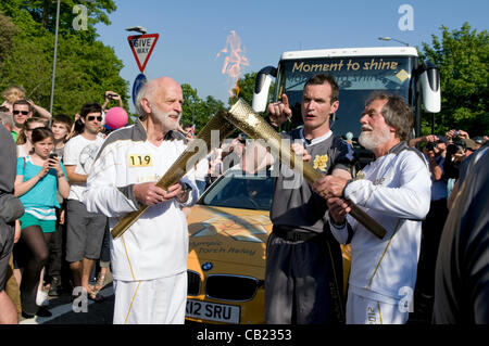 Olympische Fackel-Staffel bei Longwell Green, Bristol, UK, 2012 als zwei Träger über tauschen und die neue Fackel anzünden. Stockfoto