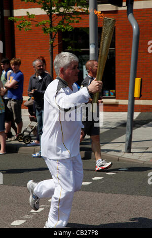 Mittwoch, 23. Mai 2012, Swindon, Wiltshire, UK. Stephen Ratcliffe trägt die Olympische Fackel durch Swindon. Steve ist Vorsitzender der Newlands Park, eine Gemeinschaft Multi Sport Veranstaltungsort, im Besitz von Cheltenham Rugby Club. Stockfoto