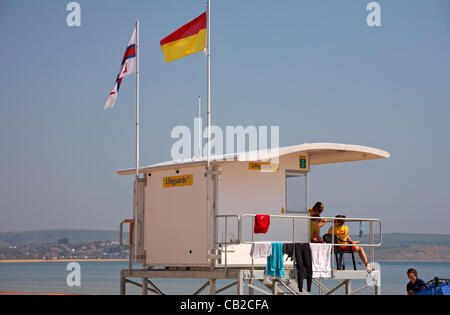 Weymouth, Dorset UK Mittwoch, 23. Mai 2012. Das Beste aus dem warmen Wetter zu machen, da die Temperaturen am Weymouth Beach, Großbritannien, steigen. RNLI-Rettungsschwimmer im Dienst an der Rettungsschwimmer-Kiosk-Hütte Stockfoto