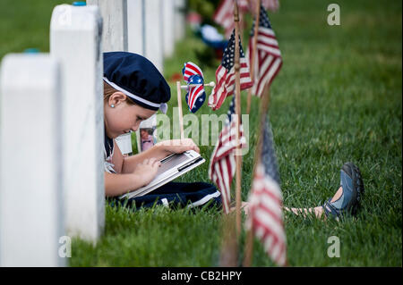 24. Mai 2012 spielt - Arlington, Virginia, USA - Emma Youngblood auf ihrem iPad in der Nähe ihres Vaters Grabstein während ein Universitätsbesuch, Abschnitt 60 am Arlington National Cemerery Donnerstag. Mitglieder des 3. Infanterieregiments, bekannt als die alte Garde, die amerikanische Flaggen vor Grabsteine und Nischen Dienst mem Stockfoto