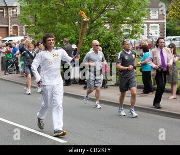 Sean Lewis Alter von 16 Jahren aus Llanbradach Handlungsinstrumente der Flamme während der Fackellauf der Olympischen Spiele London 2012 durch Abergavenny, Wales, UK auf Freitag, 25. Mai 2012 Stockfoto