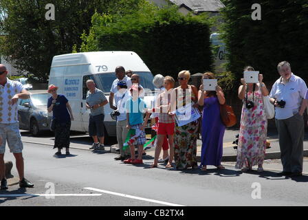 2012 Olympische Fackel Prozession erreicht Bryncethin am 26. Mai 2012. Glühend heiß, als der Fackelträger trägt stolz die renommierten Olympische Fackel durch die Hauptstraßen von Bryncethin im County Borough von Bridgend Uk, Cheers und wehenden Fahnen von Einheimischen und Besuchern, die angetreten sind Stockfoto