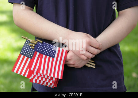 Eine männliche Jugendliche hält Miniatur amerikanische Flaggen in seiner Hand bei einer Memorial Day Zeremonie in Raleigh, North Carolina, USA, 28. Mai 2012. Stockfoto