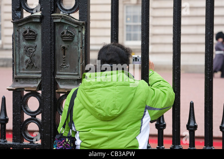 Ein Tourist nimmt das Bild von einer Königinnenwache, als es vorbei auf Patrouille am Buckingham Palace, Westminster, London geht Stockfoto