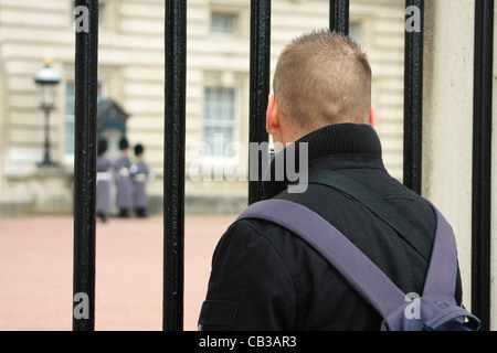 Ein Tourist nimmt das Bild der Königinnenwache, wie es auf Wache draußen Buckingham Palace, Westminster, London aussieht Stockfoto