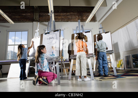 Kinder, die Zeichnung auf Staffeleien im Kunstunterricht Stockfoto