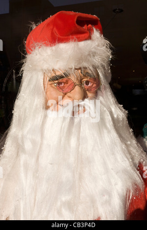 Eine Santa Christmas Party Kostüm erscheint in der Frontscheibe ein Kostüm-Shop in Goven Hill, South Glasgow. Stockfoto