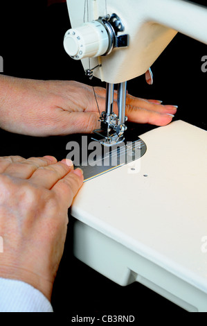 Frau mit einer inländischen elektrische Nähmaschine, um schwarzem Samt, England, UK, Westeuropa zu nähen. Stockfoto