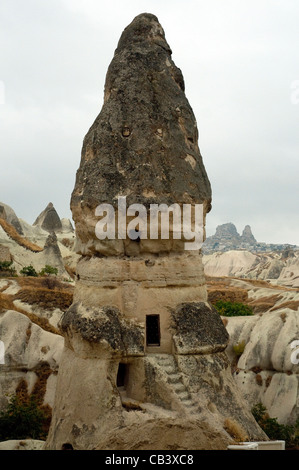 Hohe konische Felsen bieten Höhlenwohnungen in Cappadocia bizarre vulkanisch geformten Landschaft Stockfoto