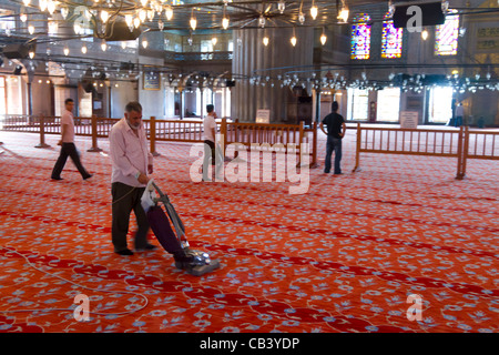 Man einen Teppich reinigen. Blaue Moschee. Istanbul, Türkei. Stockfoto