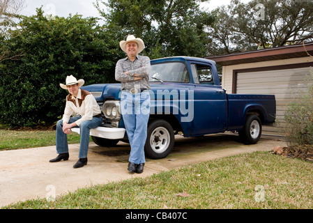 Porträt von Tex-Mex-Vater und Sohn durch einen Pick-up-Truck vor Haus Stockfoto