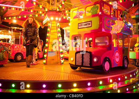 Ein junge Teenager-Mädchen schauen gelangweilt arbeiten auf eine Fahrt auf dem Aberystwyth jährliche November Jahrmarkt Rummelplatz fair, Wales UK Stockfoto