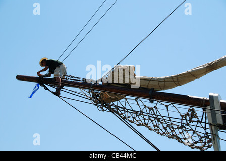 Ein Besatzungsmitglied arbeitet an der bekannten Filmprop HMS Bounty, um sich auf das Segeln vorzubereiten. Tragischerweise sank das Schiff 2012 während des Hurrikans Sandy. Stockfoto