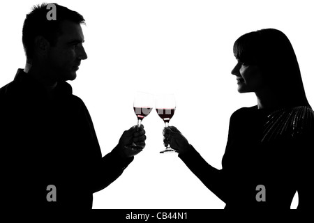 eine kaukasische paar Mann und Frau trinken Rotwein Toasten im Studio Silhouette isoliert auf weißem Hintergrund Stockfoto