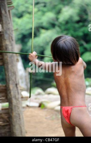 Embera gebürtiger Junge, der mit Bogen und Pfeil auf der Embera Puru indigenen Gemeinschaft in Panama Jagd spielt, Stockfoto