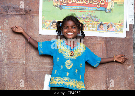 Armen indischen nomadischen Bettler Mädchen steht vor einem indischen Rama Filmplakat auf einer Hütte. Andhra Pradesh, Indien Stockfoto