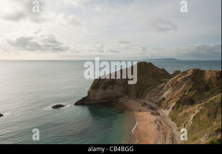 Zwei Figuren, die zu Fuß auf Mann des Krieges Bay bei Durdle Door auf die Jura-Küste in Dorset, England im Herbst Stockfoto