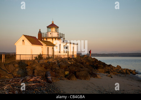 WASHINGTON - Sonnenaufgang am Westpunkt Licht an den Ufern des Puget Sound im Entdeckerpark, Seattle Stadtpark. Stockfoto