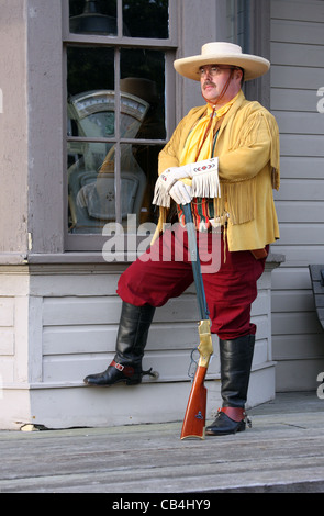 Eine südwestliche Cowboy steht man vor einem alten Zug-Depot-Fenster Stockfoto