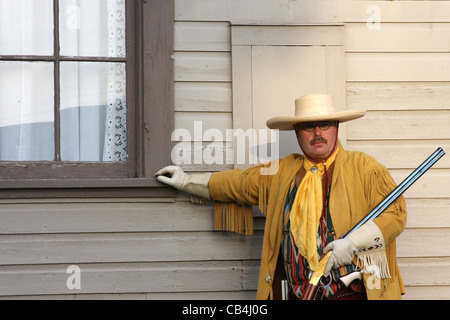 Eine südwestliche Cowboy steht man vor einem alten Zug-Depot-Fenster Stockfoto