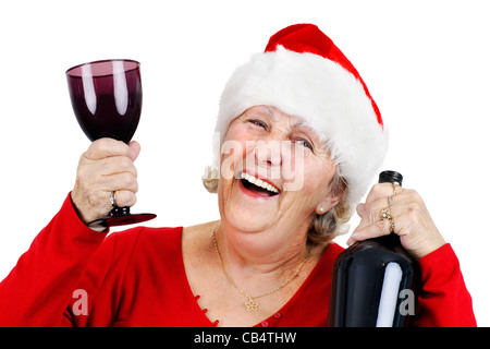 Oma oder Frau Claus hat eine tolle Zeit bei der Weihnachtsfeier hat sie trinkt und lacht während des Tragens des Weihnachtsmannes Mütze Stockfoto