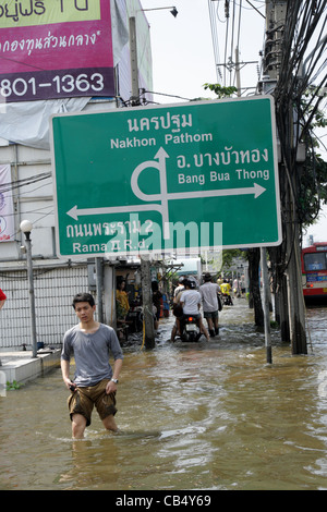 Menschen waten im Hochwasser an der Phetkasem Road in Bangkok Stockfoto