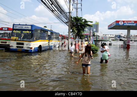 Menschen waten im Hochwasser an der Phetkasem Road in Bangkok Stockfoto