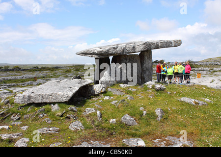 Tourguide zeigt Touristen die Poulnabrone Dolmen in die Burren, County Clare, Irland Stockfoto