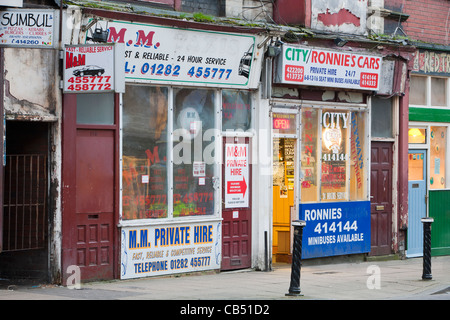 Taxiunternehmen in einem heruntergekommenen Gegend von Burnley, Lancashire, UK. Stockfoto