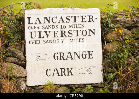 Eine alte Straßenschild Entfernungen von Cark in Cartmell, über den Sand der Morecambe Bay, Cumbria, UK zu geben. Stockfoto