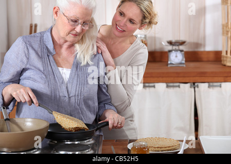 Tochter Mutter senior in der Küche zu helfen Stockfoto