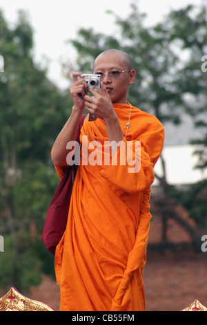 Ein buddhistischer Mönch nimmt ein Foto während eine Hommage an König Rama IX von Thailand in der Nähe von Tha Pae Gate in Chiang Mai, Thailand. Stockfoto