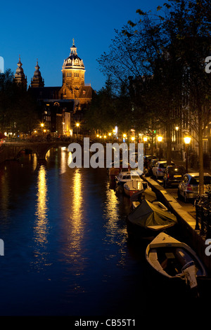 Nacht-Blick auf einen Kanal in das Rotlichtviertel mit Sint Nicolaaskerk im Hintergrund. Amsterdam, Niederlande. Stockfoto