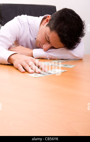 Geschäftsmann, schlafen im Büro mit der Hand auf dem Geld Stockfoto