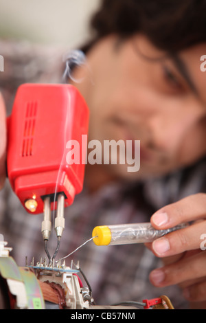 Mann mit Lötkolben Stockfoto