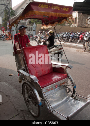 Straßenszene mit Rikscha-Fahrer auf einem Cyclo mit Arsenal Football Club Sticker in Hanoi, Vietnam Stockfoto