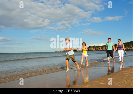 Familie am Strand entlang spazieren. Stockfoto