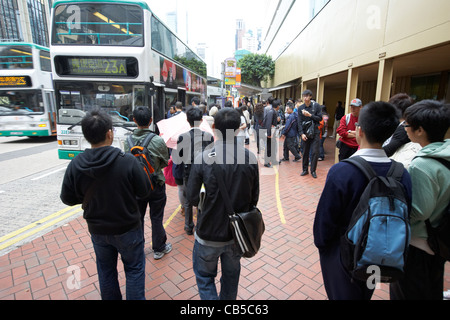 chinesische Leute Schlange stehen an einer Bushaltestelle in die Innenstadt von Admiralität Bezirk Hong Kong Insel Sonderverwaltungsregion Hongkong china Stockfoto