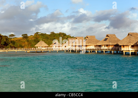 Seeküste mit Palmen und kleinen Häusern auf dem Wasser. Stockfoto