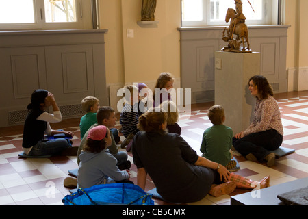 junge Kinder in der Klasse sitzen vor mittelalterlichen Skulptur auf Exkursion mit Lehrer, Bode-Museum, Berlin, Deutschland Stockfoto