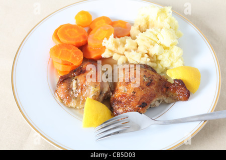 Ein hohen Winkel Überblick Hähnchenschenkel, adobado in Zitronensaft und Kräutern und gebraten, serviert mit Kartoffelpüree und Möhren Stockfoto