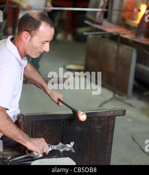 Ein Handwerker in einer Murano-Fabrik arbeitet auf die Produktion von ein Stück dekorativen Glas Stockfoto