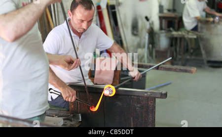 Ein Handwerker in einer Murano-Fabrik arbeitet auf die Produktion von ein Stück dekorativen Glas Stockfoto