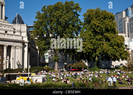 Mitarbeiter im Büro sitzt in einem Park in der Mittagspause, City of London, England Stockfoto