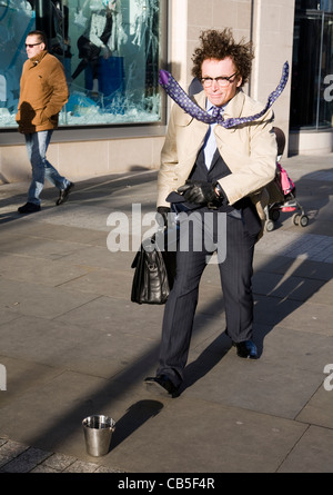 "Mann in Eile" stationäre Künstler - bewegungslos auf den Straßen der Stadt, mit Aktenkoffer und erhöhten versteift, Krawatte, Manchester UK Stockfoto