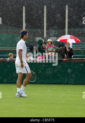 18.06.2011. Rafael Nadal ESP (1) üben mit Mikhail Youzhny RUS (18) auf Court 6. Rafael Nadal räumt Niederlage gegen den Regen. Stockfoto