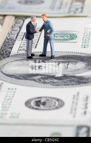 Miniatur-Geschäftsmann machen eine finanzielle Sache (selektive und weichen Fokus) Stockfoto