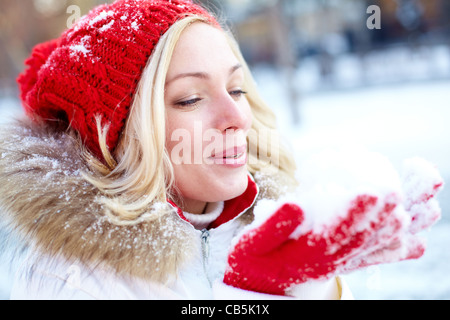 Porträt von glücklichen Mädchen halten Schnee auf Palmen an Wintertag Stockfoto