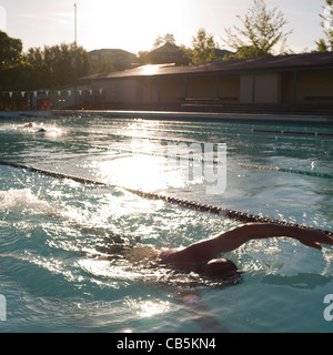Ältere Erwachsene Schwimmen im Außenpool mit Abend Sonnenlicht Stockfoto