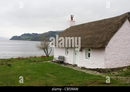 Ehemaliges Fischerhaus Schutzhütte (jetzt ein Selbstversorger Reetdachhaus im Besitz von Kilfinichan Estate) mit Blick auf Loch Scridain. Stockfoto